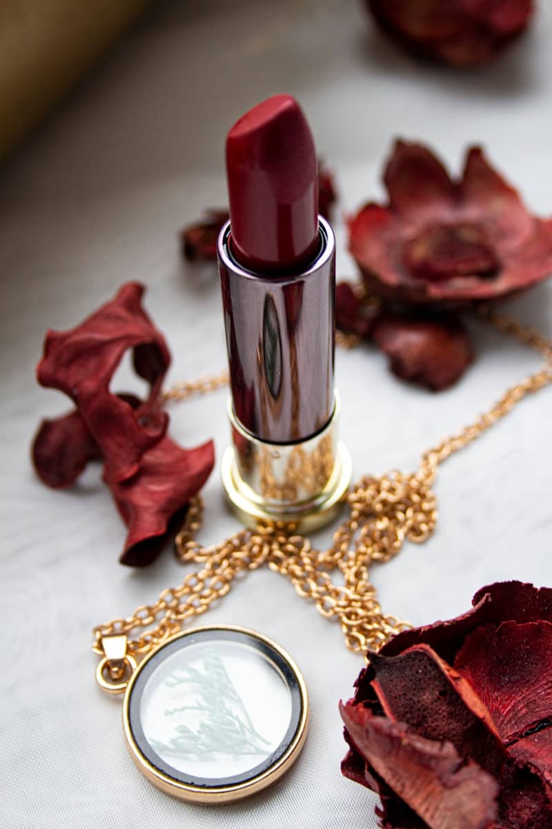 gold and red lipstick on red textile