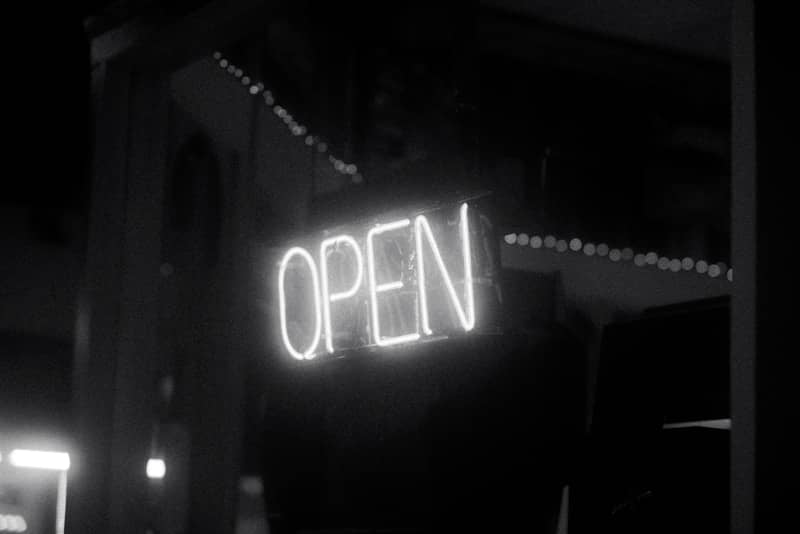 Neon "open" sign illuminates the night.