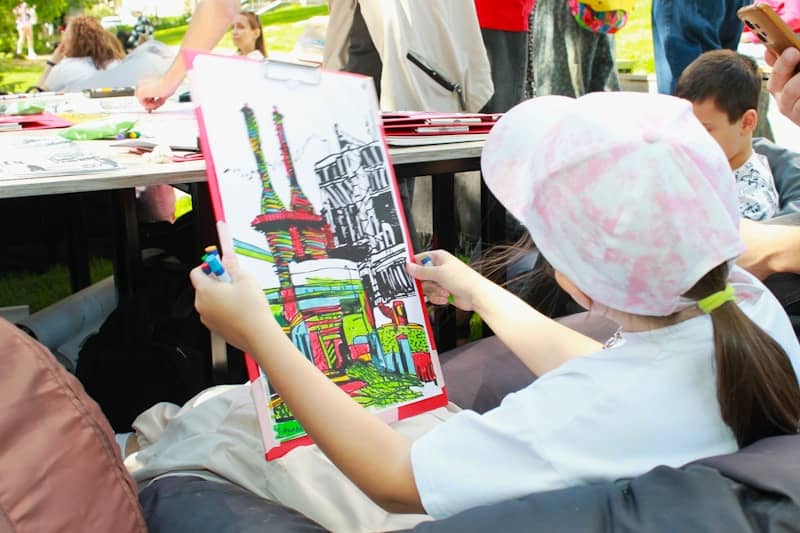 A young girl colorfully paints a picture.