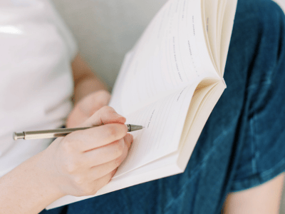 Woman curled up writing in her journal on Blue Monday