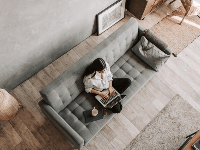 Woman working from a quiet couch—visual for saying no without guilt and setting boundaries as an introverted coach in business.