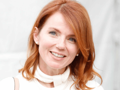 Geri Halliwell smiling in a white outfit, reminding us to celebrate small wins and quiet success. Inspirational message for entrepreneurs.