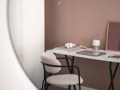 Minimal blush-toned desk with chair, notebook, and lamp. Calm workspace representing simplified coaching business support.