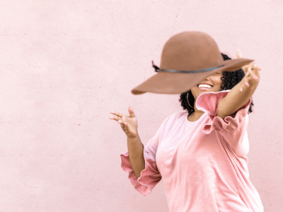 Woman tossing her hat at the camera in good fun - having a glow up!