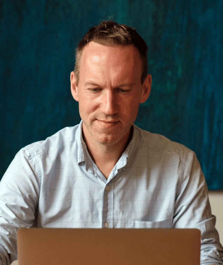 A photo of Scott Robson at his laptop.