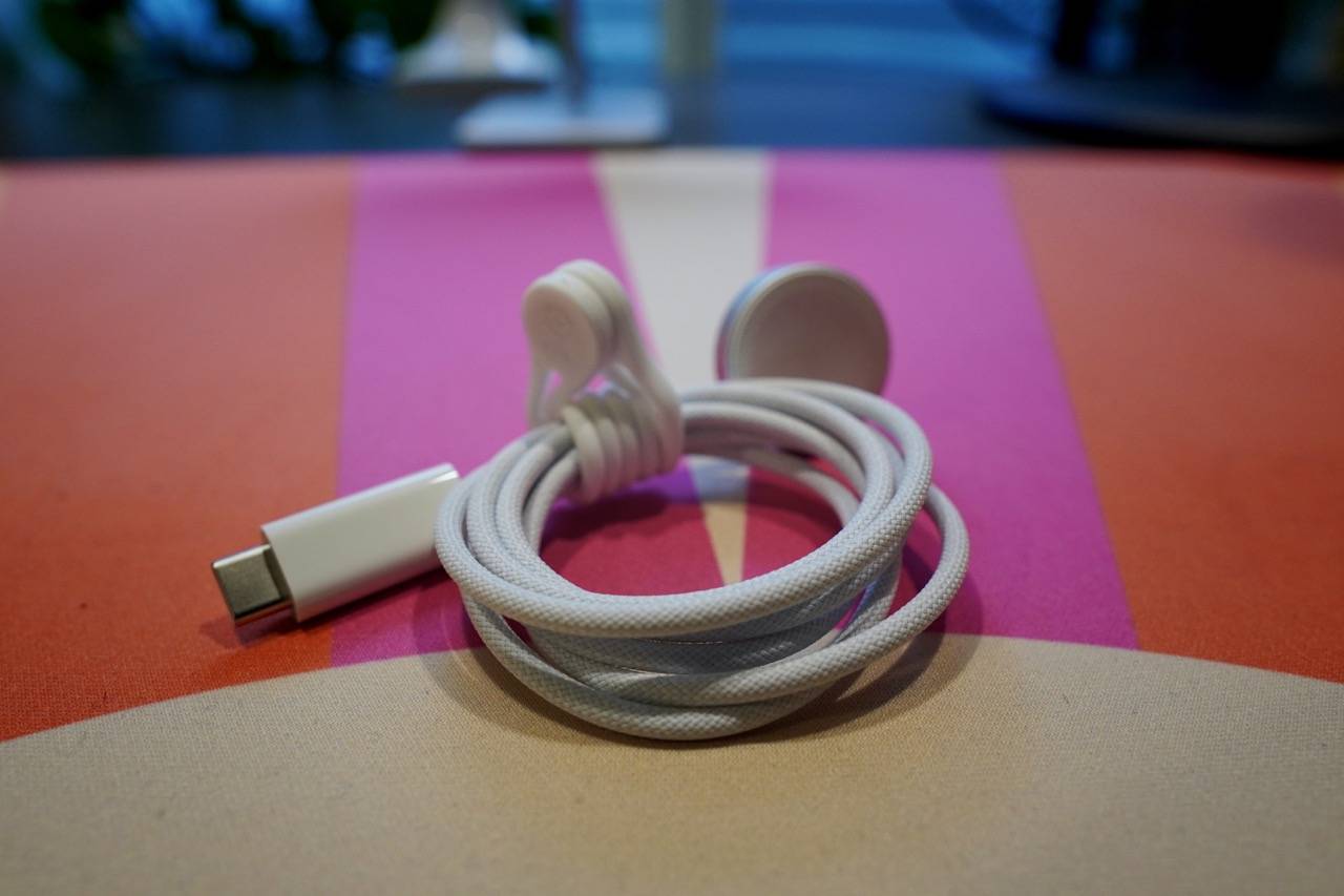 colored desk mat with a white woven Apple Watch cable