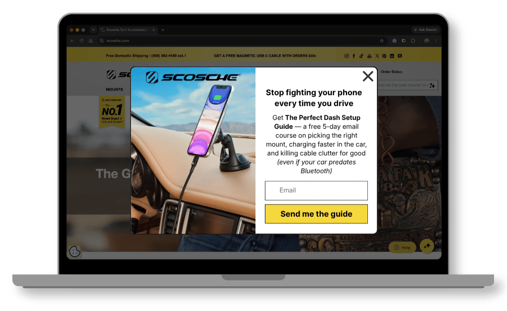 Redesigned Scosche popup on a laptop screen: a centered modal with a photo of a phone on a dash mount, the headline "Stop fighting your phone every time you drive," an email field, and a yellow "Send me the guide" button.