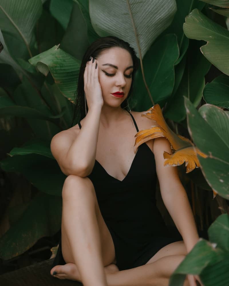 a woman sitting on the ground with her hands on her head