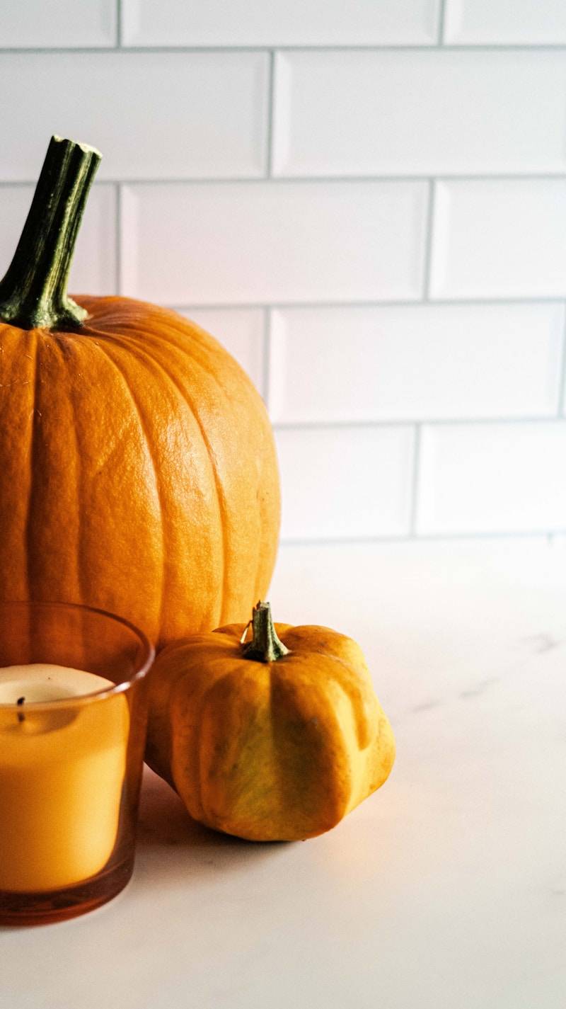 A candle and a pumpkin on a table