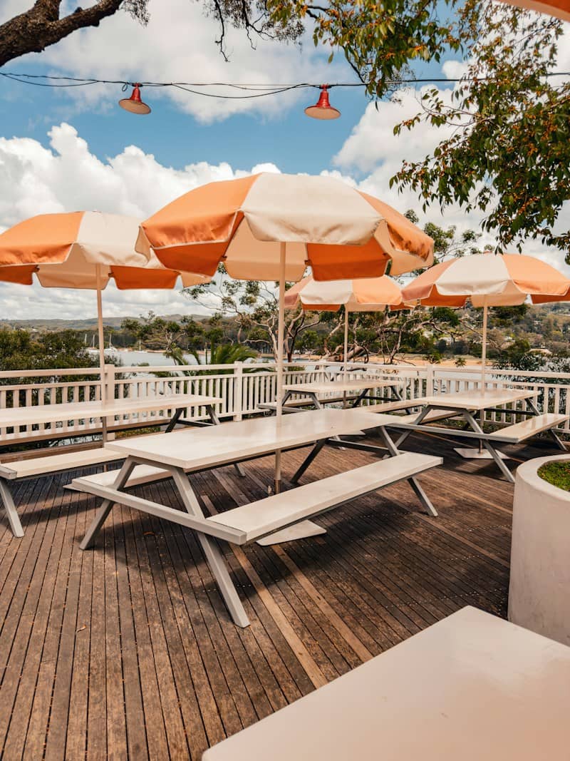 Outdoor deck with picnic tables and orange umbrellas