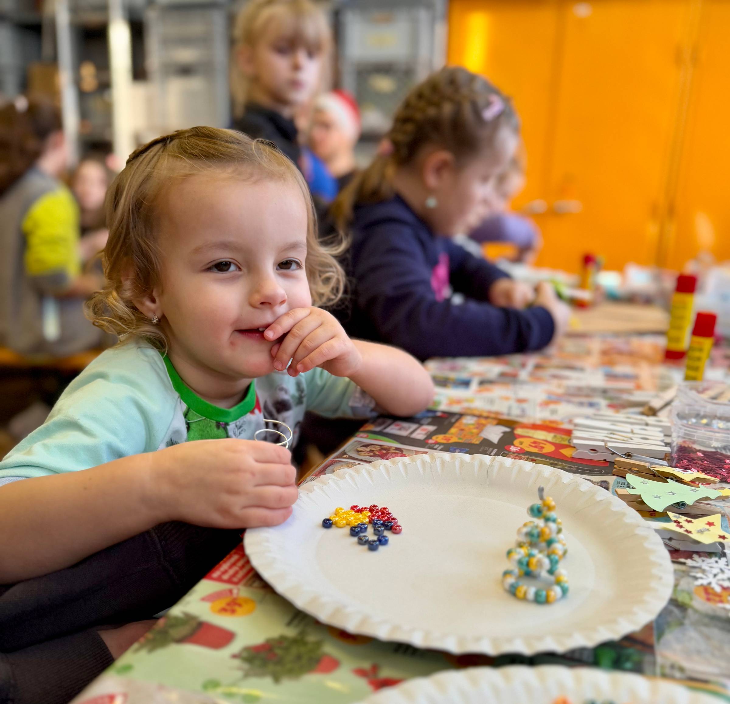 Dítě vyrábějící stromeček z korálků