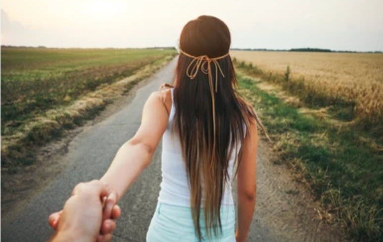 a woman leading the way, arm reaching back to pull someone along by the hand