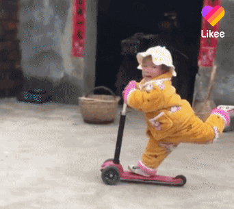 gif of a scootering toddler wearing a snowsuit and floppy hat