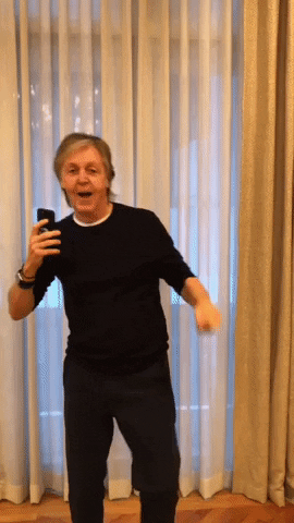 GIF of Paul McCartney goofily waddling towards the camera and grinning