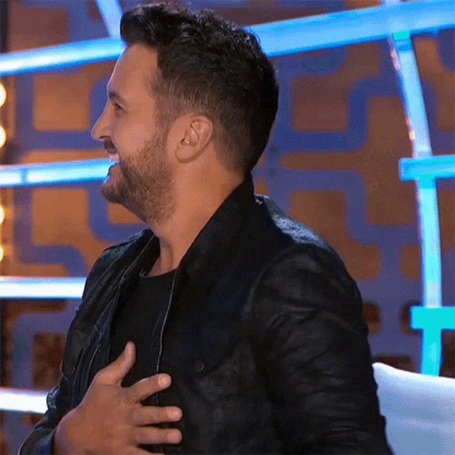 Luke Bryan smiling with hand on heart, on American Idol