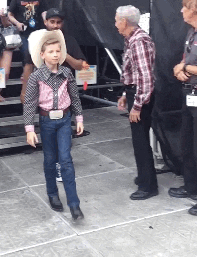GIF of a preteen cowboy whirling and then doing finger guns