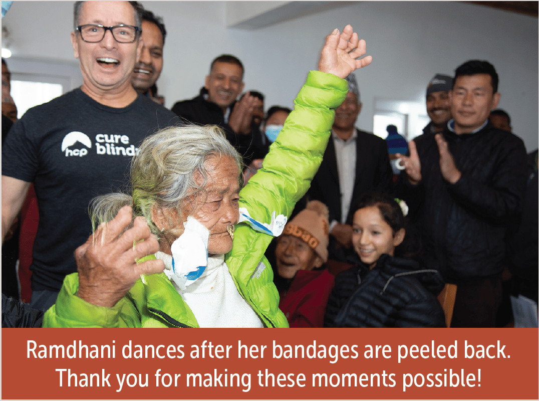 An older woman dancing in the foreground. She has bandages that have been removed but not yet taken off her face. She had eye surgery recently. The woman is dancing and happy. The people in the background are enjoying the sight!