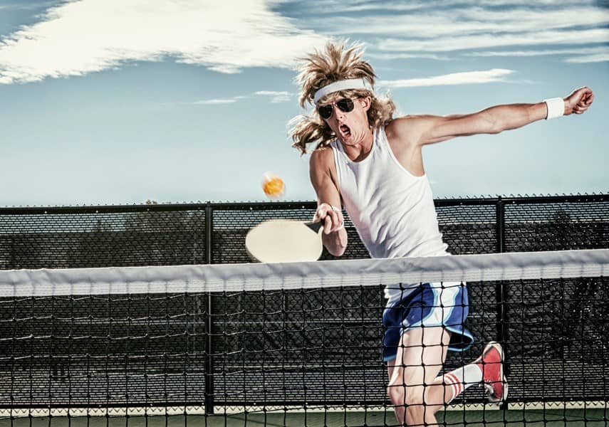 man with mullet playing pickleball