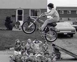 a boy jumping over a group of kids in the '70s