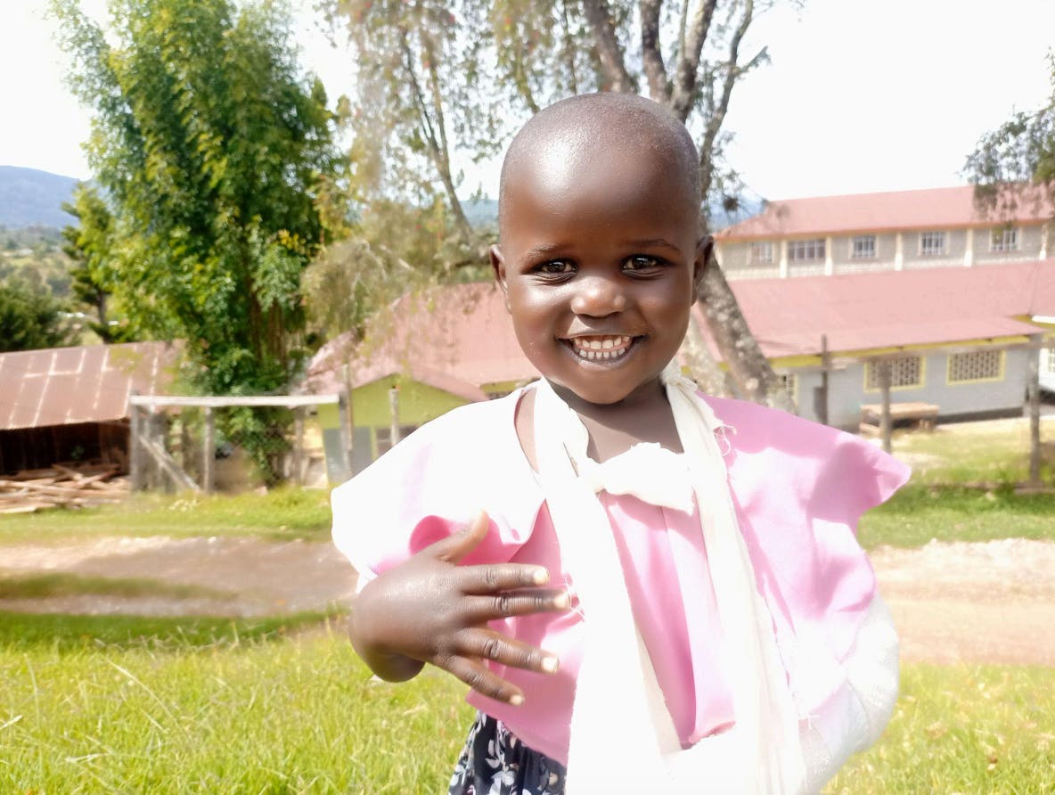 photo of a girl named Winjoy who is beaming with joy after a surgery repaired her broken arm