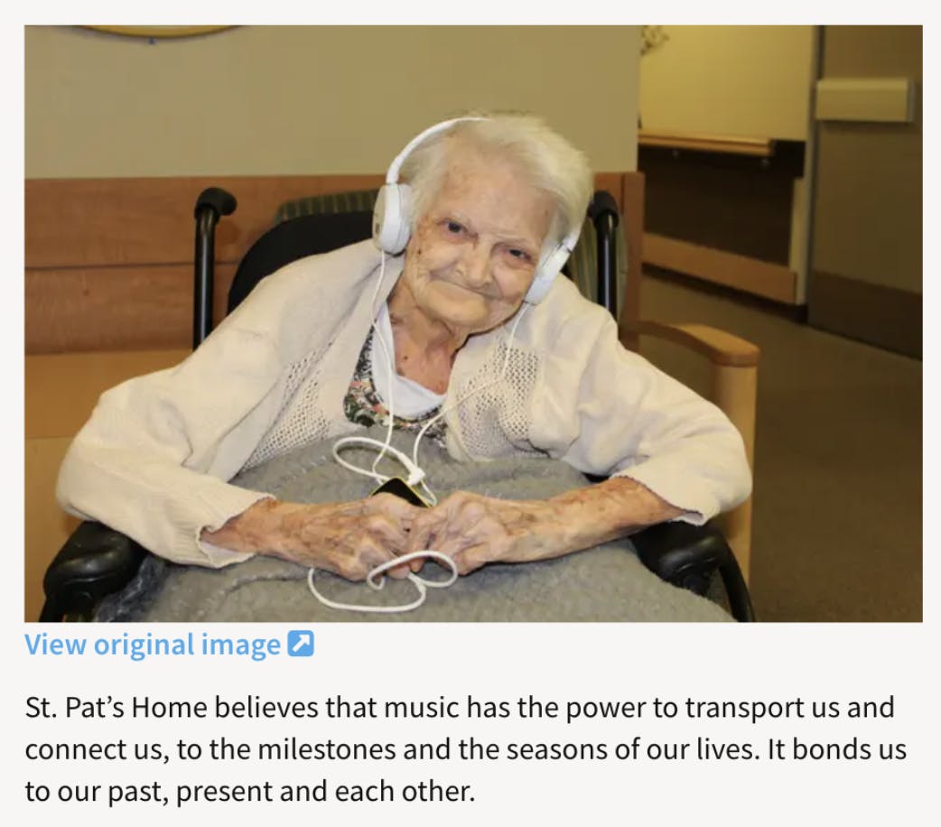 image of an elder woman in a wheelchair listening to music through headphones
