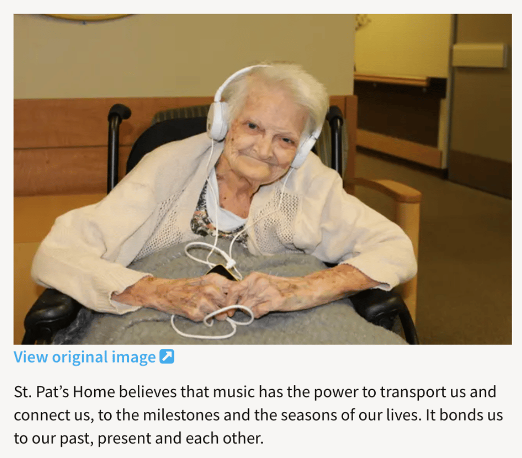 image of an elder woman in a wheelchair listening to music through headphones