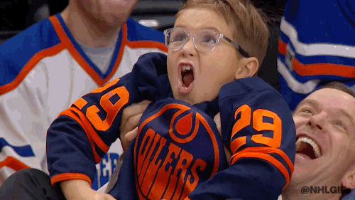 A young sports fan in the audience cheering wildly