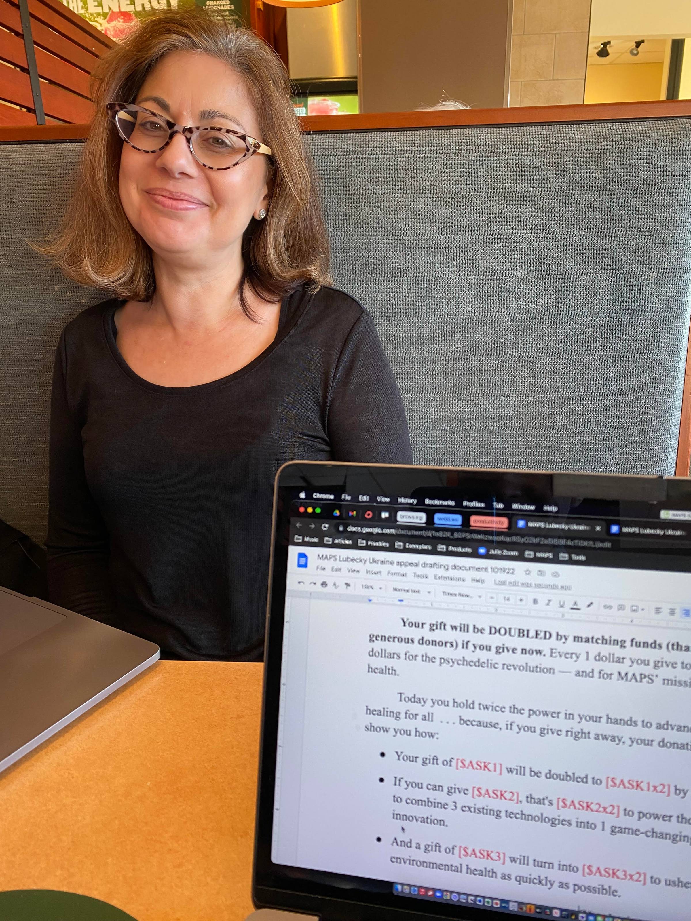 photo of Julie Cooper working at her computer at a Panera booth