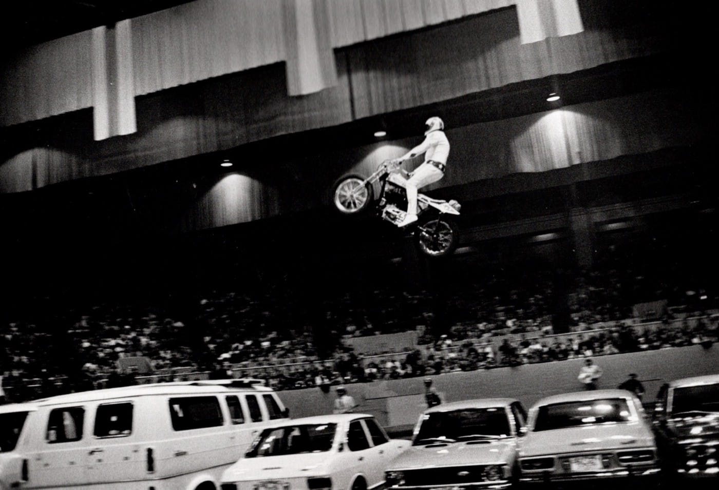 Evel Knievel jumps his motorcycle over a row of cars