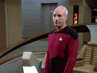 Captain Picard from Star Trek wearing his red Starfleet uniform ; he is giving a half-hearted wave