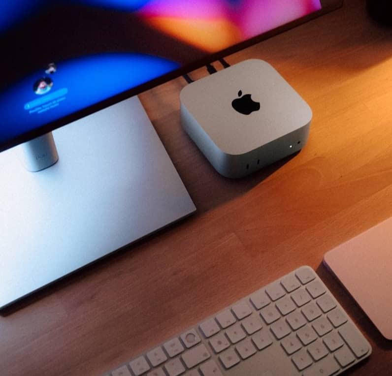 An apple computer sitting on top of a wooden desk