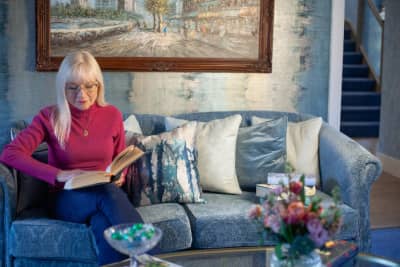 April Harris reading on a cosy sofa