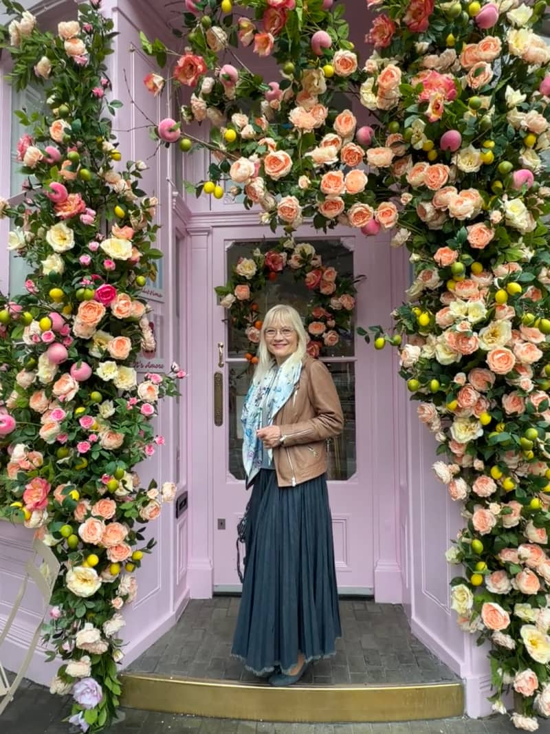 April J Harris standing in the floral arched doorway of Peggy Porschen London