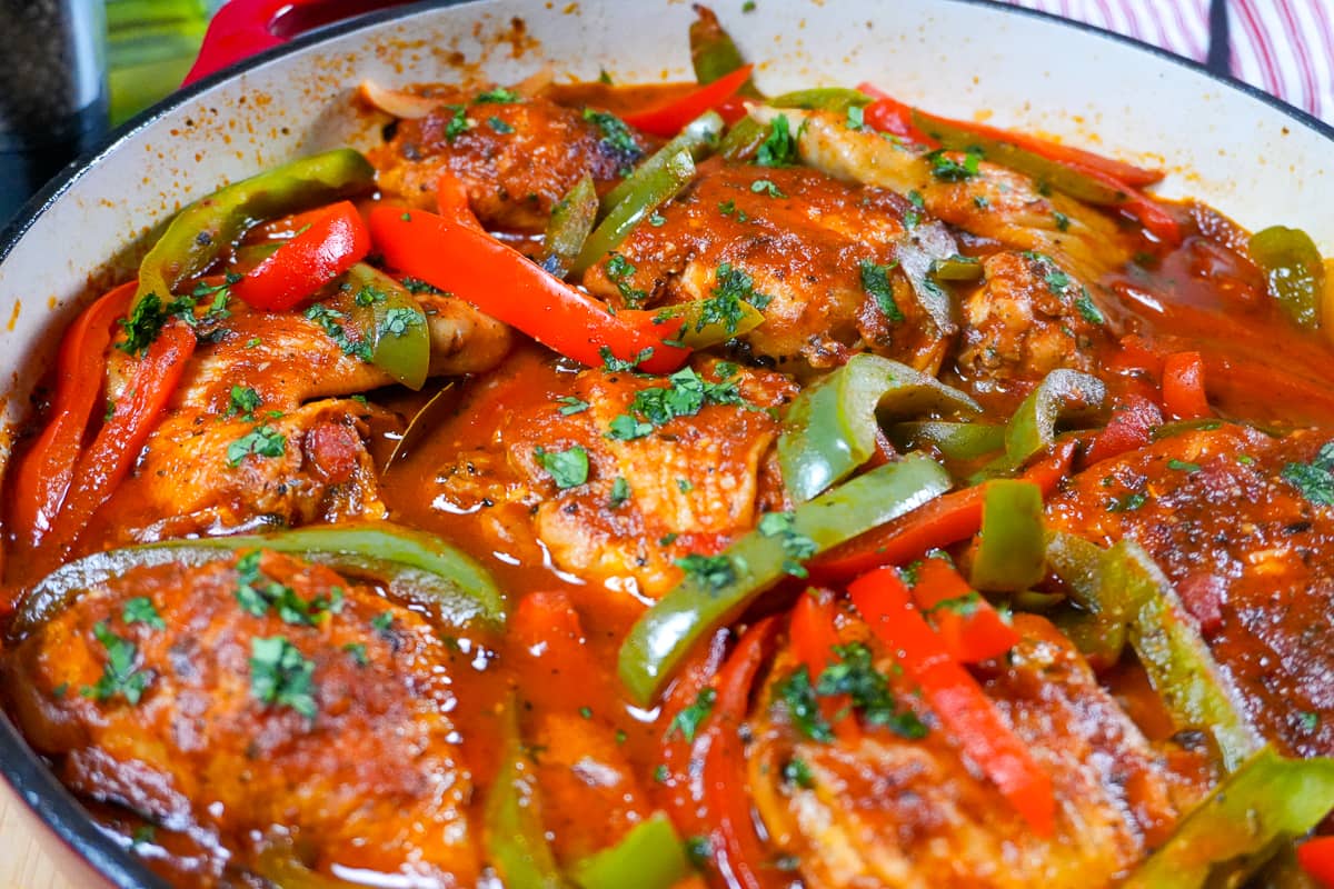 braised chicken mexican style in a cast iron enamel large dutch oven.