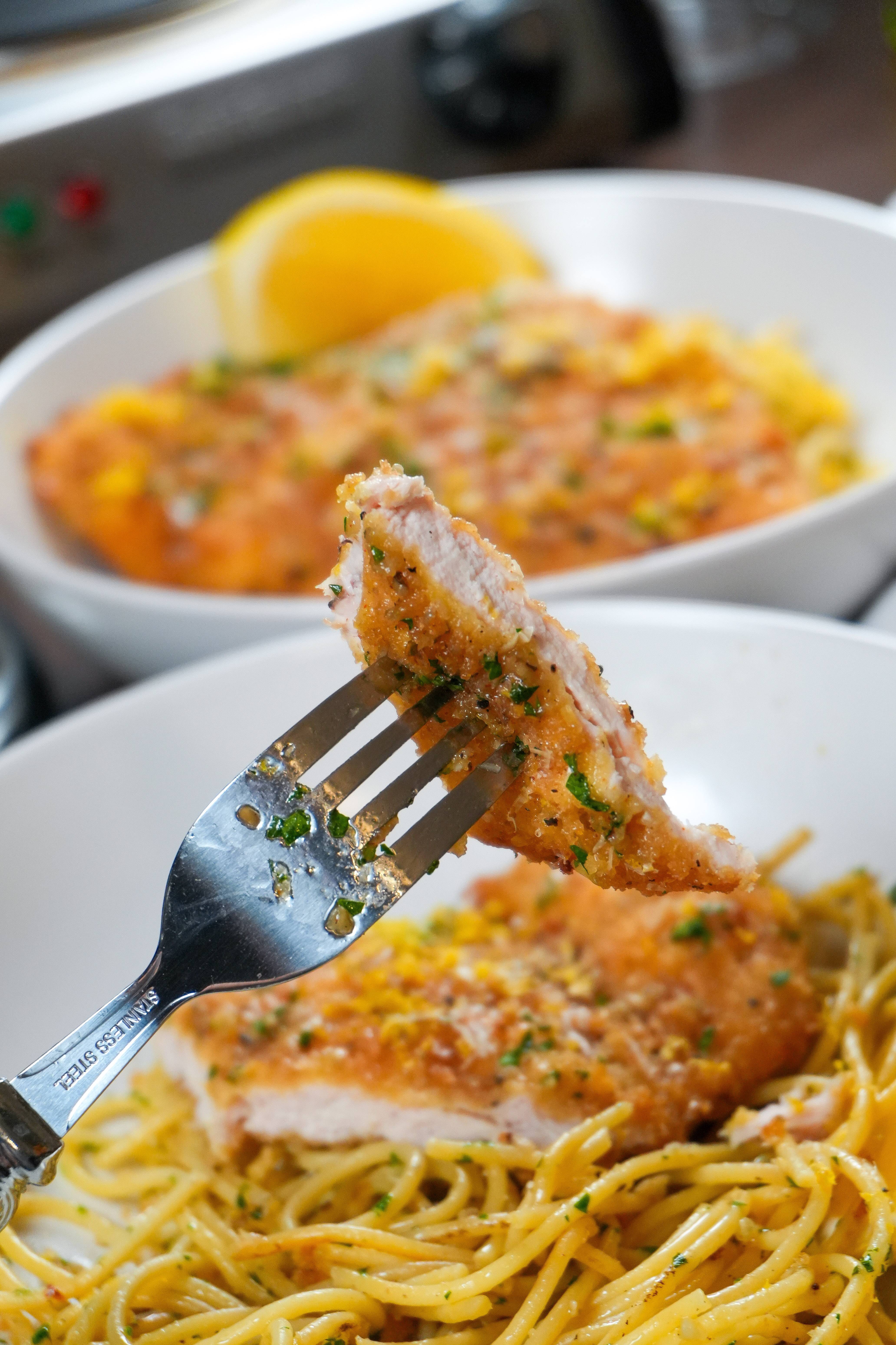 Image: Lemon Pepper Chicken Cutlet in a bowl with Herbed-Parmesan and Olive Oil tossed spaghetti.