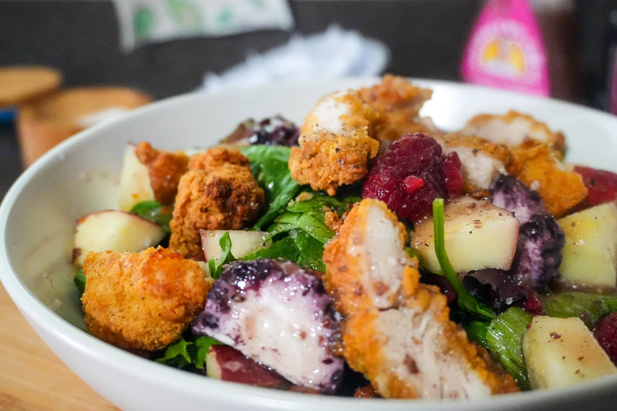 Fresh Berry Apple Pecan Chicken Salad with Goat Cheese in a bowl.