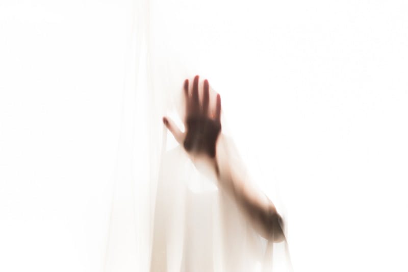 a blurry image of a hand reaching out of a window