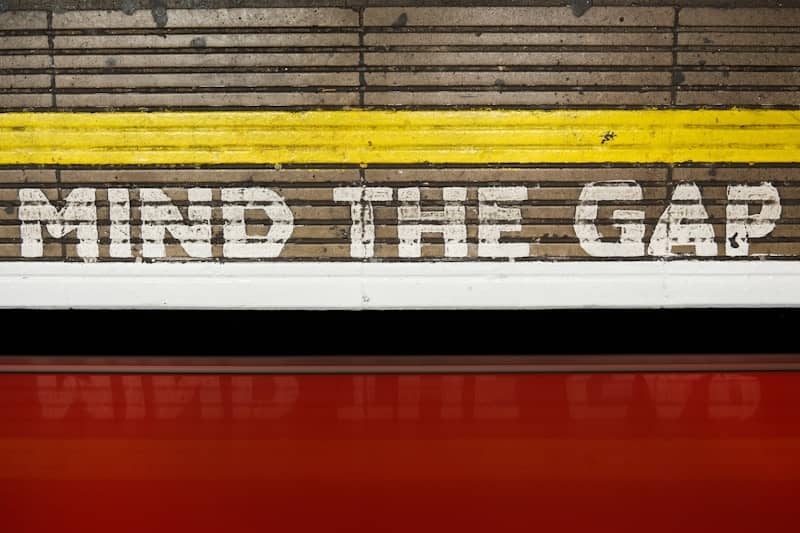 A sign that says mind the gap on the side of a train