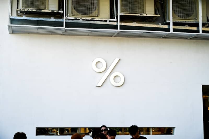 White wall with a large percent sign logo