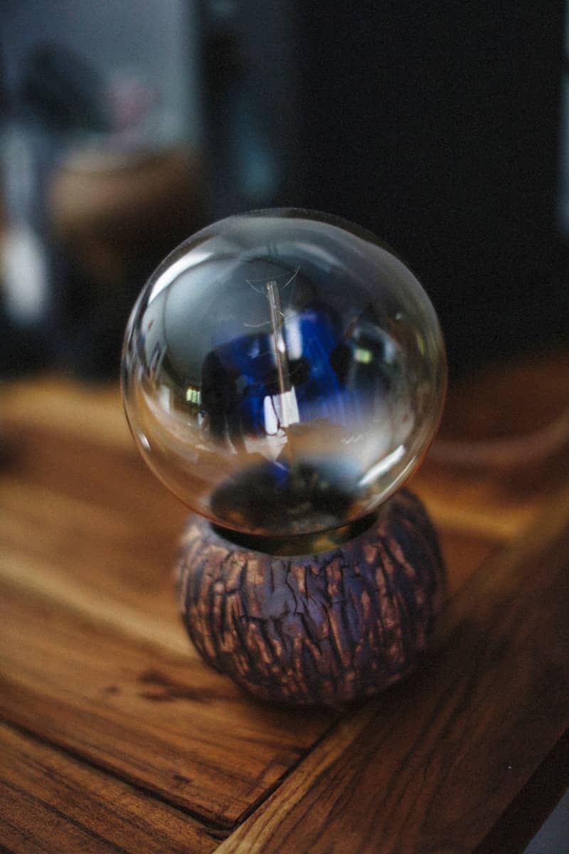 A clear orb rests upon a wooden stand.