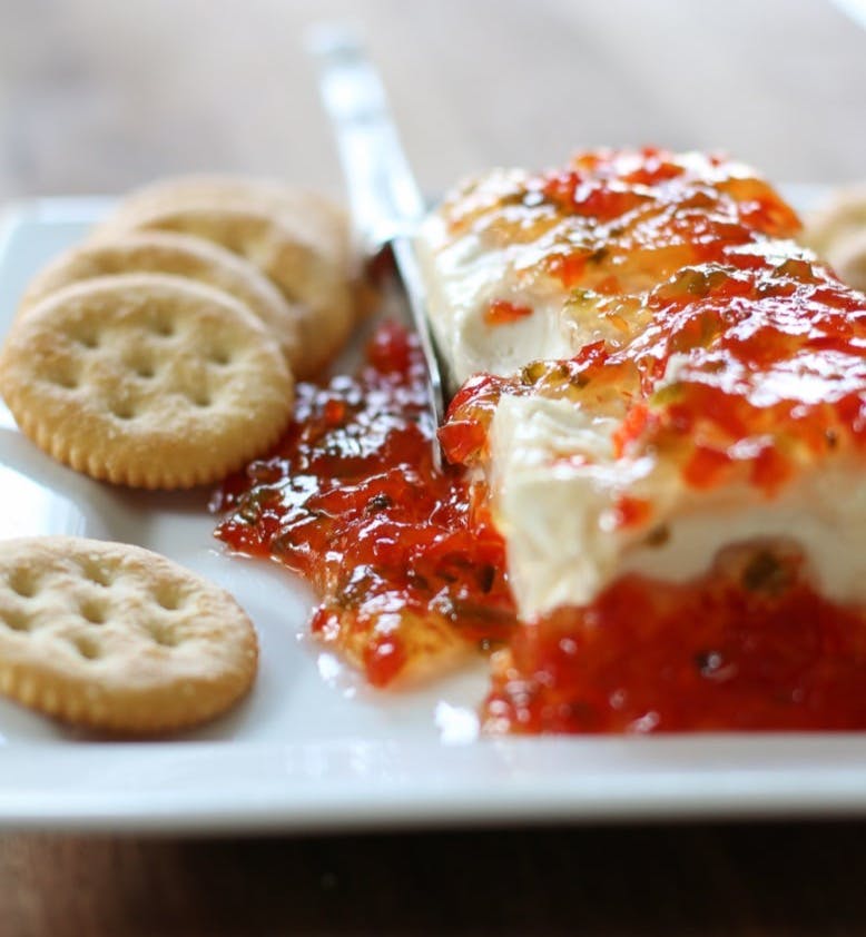 block of cream cheese covered in pepper jelly