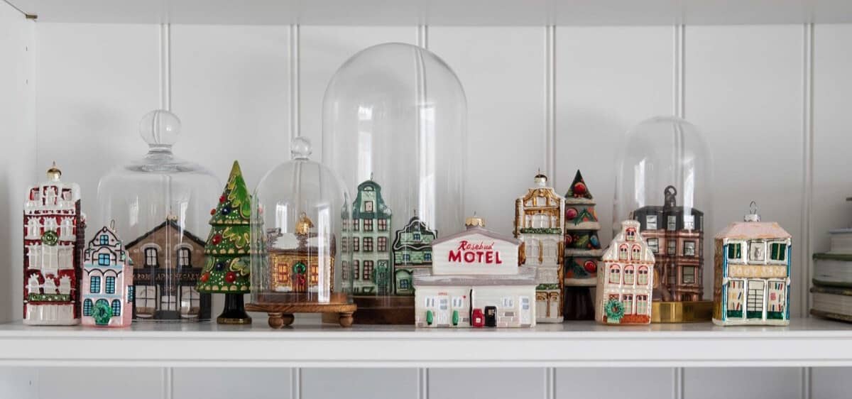 bookcase shelves decorated for Christmas with glass house ornaments.