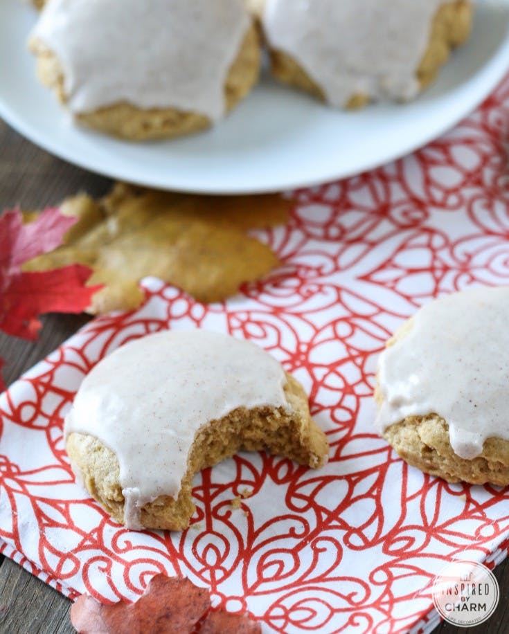 Soft Pumpkin Sugar Cookies on a colorful napkin. One had a bite taken out. 