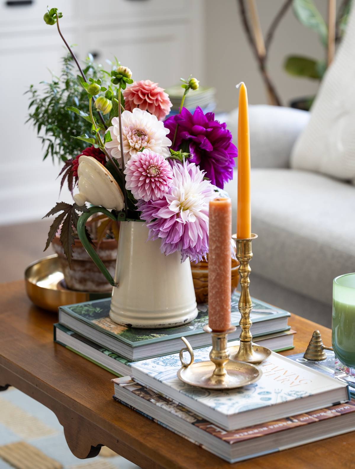 dahlias in a vase on a coffee table with candlestick