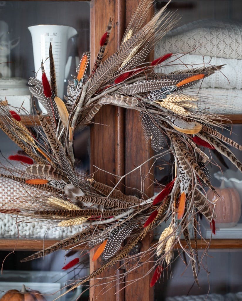 DIY Feather Wreath for Fall on cabinet.