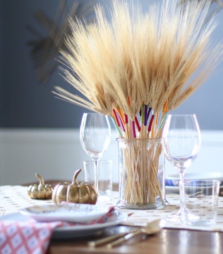 DIY Color Wrapped Wheat in glass vase on a table.