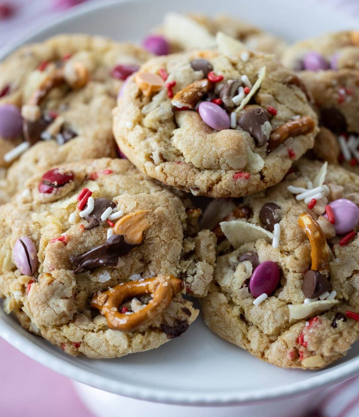 array of Kitchen Sink Cookies for Valentine’s Day on a cake stand.