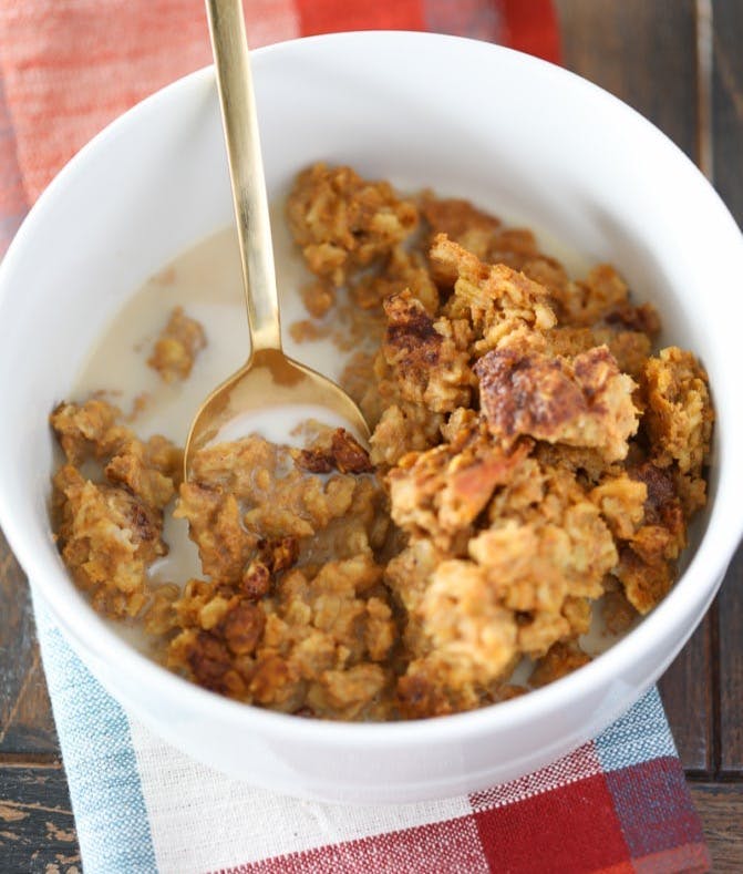 baked pumpkin oatmeal in a bowl with a spoon on a napkin.