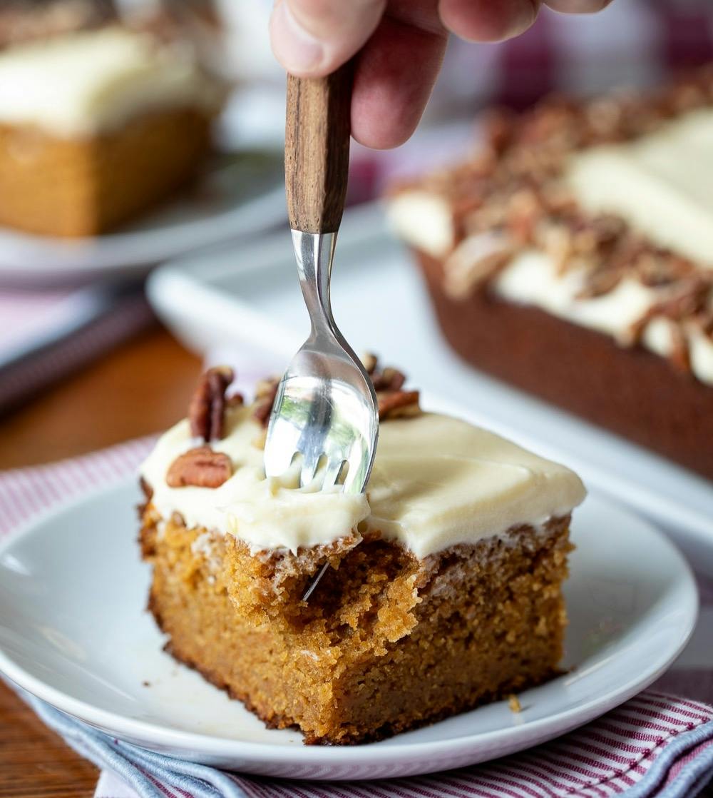 hand with a fork taking a bite of sweet potato cake. 