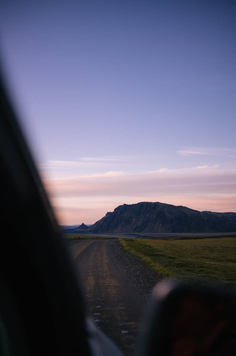 A view from inside a vehicle of a dirt road